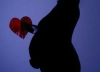 Donna incinta con un cuore rosso