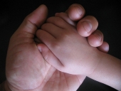 Mano di un adulto e di un bambino