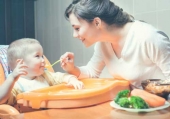 Mamma che imbocca bebé con la pastina