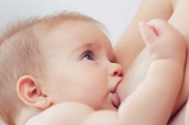 Neonata al seno che poppa